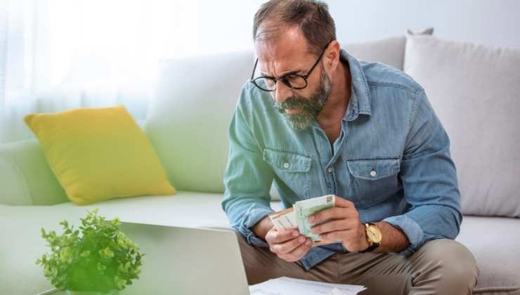 uomo contrariato conta soldi